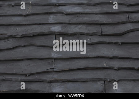 Gestapelten Brettern, ein Dach mit schwarzem Holz Schindeln, Stockfoto