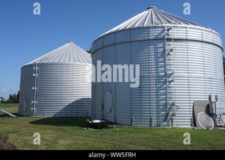 Zwei silberne Silos vor blauem Himmel Stockfoto