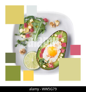 Trendfarbe passende Palette von Bild von Avocado Boot gebacken mit Schinken würfeln, Wachtel Ei und Käse mit grünen Rucola Salat serviert. Stockfoto