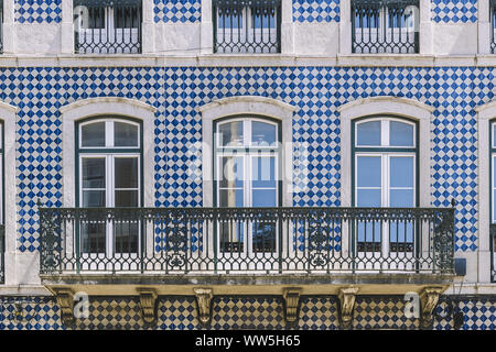 Typische historische vintage Hausfassade mit Fenstern und Balkon in einem alten Fliesen Fassade mit geometrischen Muster, malerische Architektur in Lissabon, Portu Stockfoto