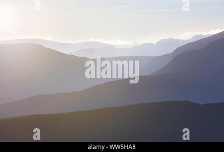 Die warme Sonne kriechen in auf einem nebligen kalten Morgen über den Grat Linien der Derwent Fells im englischen Lake District, England. Stockfoto