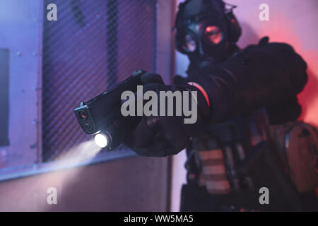 Terroristische mit Gasmaske holding Gun und mit dem Ziel ein Ziel in den Hangar Stockfoto