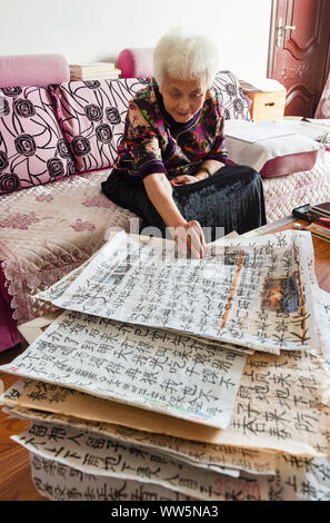 (190913) -- SUIHUA, Sept. 13, 2019 (Xinhua) - Jiang Shumei durchsucht Ihre Kalligraphien in Beilin District der Stadt Suihua, im Nordosten der chinesischen Provinz Heilongjiang, Sept. 12, 2019. Geboren 1937, Jiang war Analphabet vor dem Alter von 60. Zu entlasten Jiangs Not nach dem Tod ihres Mannes im Jahr 1996 bei einem Autounfall, ihre Tochter Zhang kränklichen lehrte die gealterte Frau lesen und schreiben Seitdem. Mit der Unterstützung ihrer Tochter, Jiang versucht, ein Buch zu schreiben. In 2013, Jiang's erstes Buch veröffentlicht wurde. Bislang hat der 82-jährige Schriftsteller hat fünf Bücher veröffentlicht und gewann mehrere Preise. Stockfoto
