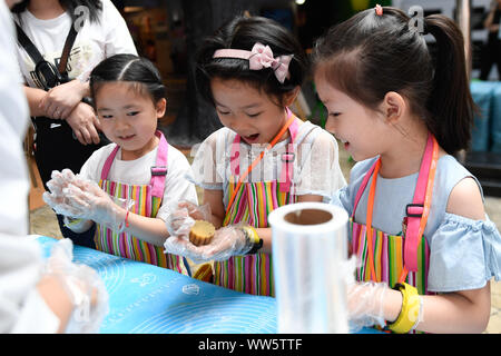 (190913) - Hangzhou, Sept. 13, 2019 (Xinhua) - Kinder lernen mooncakes bei einer Aktivität das Mondfest in Hangzhou zu feiern, der ostchinesischen Provinz Zhejiang, Sept. 13, 2019. Kinder nahmen an verschiedenen Aktivitäten wie Basteln und mooncake der Traditionellen Chinesischen Festival am Freitag zu genießen. (Xinhua / Huang Zongzhi) Stockfoto