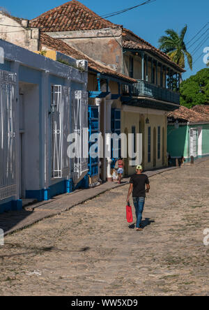 Ein Mann mit einer Tasche in der Hand Straße mit Kopfsteinpflaster, Trinidad, Kuba Stockfoto