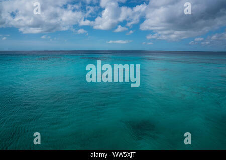 Türkisfarbene ruhige See mit blauem Himmel und Wolken, Stockfoto