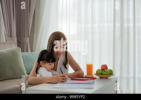 Asiatische Mutter spielt mit ihren Toddler zusammen mit Buntstifte am Tisch im Wohnzimmer zu Hause. Stockfoto