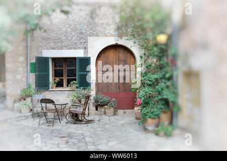 Spanien, Mallorca, Fornalutx, Stühle, Tisch, Sitze vor dem Haus, Tür, Tor, Fenster, Topfpflanzen, Haus Nummer 6, teilweise verschwimmen, digital bearbeitet Stockfoto