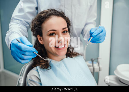 Gesundheitswesen und Medizin Konzept. Zahnarzt untersucht die Mundhöhle eines jungen Patienten im Zahnarztstuhl. Stockfoto