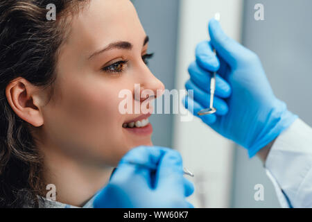 Zahnarzt Prüfung der Zähne des Patienten in den Zahnarzt. Von der Seite. Stockfoto