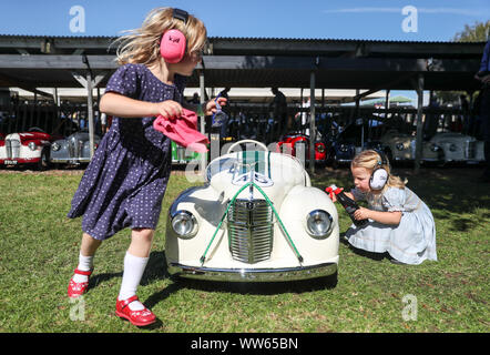 Poppy, sechs (links) und ihre Schwester Milly, drei, von Gloucestershire, polnisch Ihre Austin J40 Pedal Car vor den Samstag Settrington Schale, während Tag 1 des Goodwood Revival im Goodwood Motor Circuit, Chichester. Stockfoto