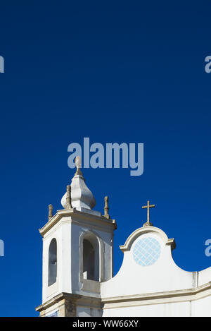 Weiße Kirche mit Dach und Glockenturm vor blauem Himmel Stockfoto