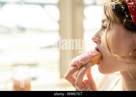Porträt einer Frau, die essen einen Donut Stockfoto