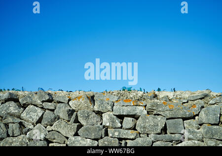 Glasscherben auf einem Stein Wand vor blauem Himmel Stockfoto