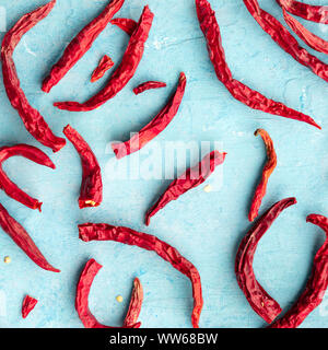 Trockene rote Peperoni auf blauem Hintergrund, Overhead Platz schoß Stockfoto