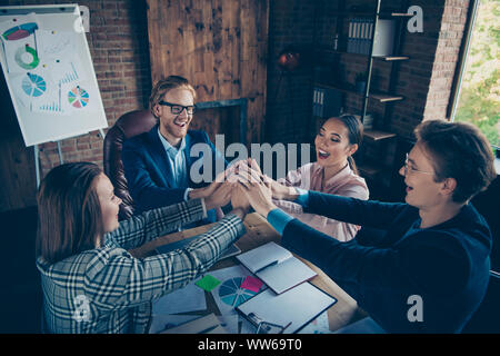 Vier schön chic elegante stilvolle Heiter froh ekstatisch business Haie Experten sammeln Termin setzen die Hände über desktop Charts auf Moderne Stockfoto