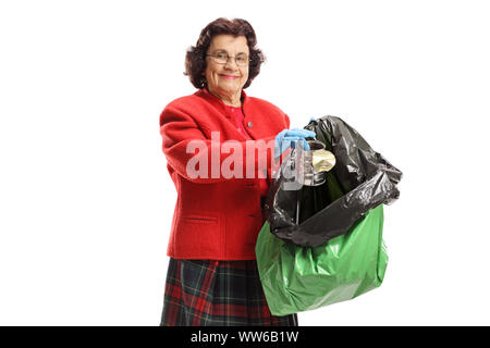 Reife Frau werfen einer Blechdose in einem Müllsack auf weißem Hintergrund Stockfoto