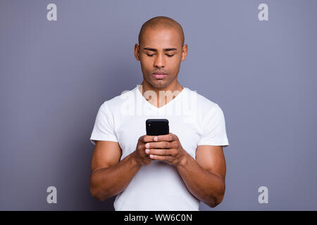 Nahaufnahme Foto starken gesunden dunkle haut er ihm seine Macho kahle Telefon armen Leser nicht lächeln politische Sport Nachrichten tragen weiße t Stockfoto
