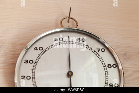 Analoge hygrometer Hängen auf Holz- wand, Nahaufnahme. Dieses Instrument verwendet, um die Menge an Feuchtigkeit und Wasserdampf in der Atmosphäre zu messen. Stockfoto