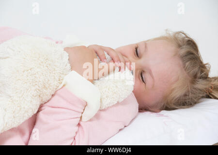 Mädchen mit Kuscheltier im Bett, Porträt Stockfoto