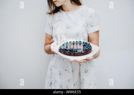 Frau mit einem Blueberry Chocolate Brownie Kuchen Stockfoto
