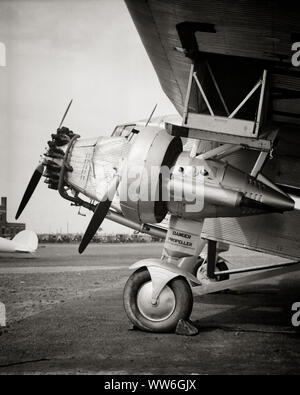 1920er Jahre 1930er Jahre VOR EINEM FORD TRI MOTOR PROPELLER FLUGZEUG WORTE ÜBER DEN GEFAHR PROPELLER-q 74090 CPC 001 HARS FORTSCHRITT INNOVATION AVIATION KONZEPTIONELLE STILVOLLE TIN GOOSE TRI-MOTOR IM ART DÉCO-STIL DER ZIVILLUFTFAHRT FORD TRIMOTOR SCHWARZ UND WEISS ALTMODISCHE TAT TRANSKONTINENTALE LUFTVERKEHR Stockfoto