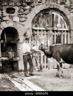 1920 s MANN MILCHBAUERN STEHEN GUT IM ALTEN STEINMAUER HOLDING METALL EIMER WASSER FÜR KUH ZU TRINKEN LOIRETAL FRANKREICH - r 3718 HAR 001 HARS LANDWIRTSCHAFT MÄNNER EUROPA LANDWIRTSCHAFT B&W SCHNURRBART ALTEN RUSTIKALEN EUROPÄISCHEN SCHNURRBÄRTE EIMER AUSSEN LANDWIRTE GESICHTSBEHAARUNG BERUFE VERBINDUNG LOIRE ZUSAMMENARBEIT Mitte - Mitte - erwachsenen Mann SCHWARZ UND WEISS KAUKASISCHEN ETHNIE HAR 001 ALTMODISCH Stockfoto