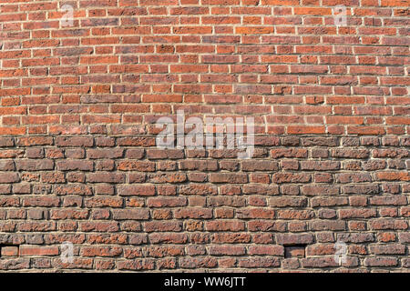 Sehr altes Mauerwerk aus rotem Backstein. Wand mit Gips abgefallen
