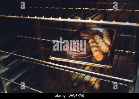 Kochen Wurst in den Ofen. Fast Food Street. Gebratene Würstchen Stockfoto