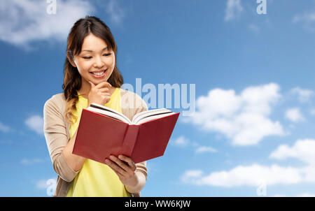 Gerne asiatische Frau mit Buch Stockfoto