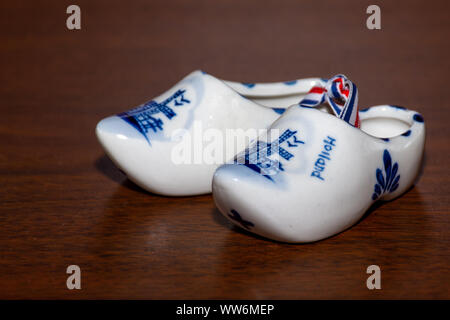 Delfter Blau Figur der niederländischen Holzschuhe Porzellan. Souvenir aus Holland/Niederlande. Auf braunem Hintergrund isoliert. Stockfoto