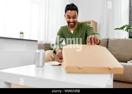 Indische Mann innerhalb von Takeaway pizza box suchen Stockfoto