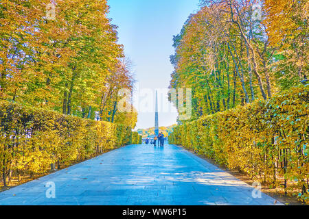 Kiew, Ukraine - Oktober 19, 2018: Die Gasse im Herbst Park der ewigen Herrlichkeit führt zum Grab des Unbekannten Soldaten mit hohen steinernen Obelisk und Ewige F Stockfoto