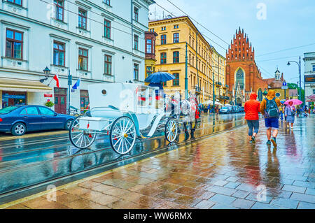 Krakau, Polen - 13. Juni, 2018: Die städtische Szene in der regnerischen Tag mit der Kutsche befreien alle heiligen Platz, am 13. Juni in Krakau Stockfoto