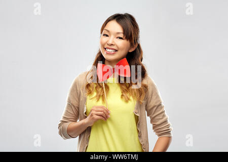 Gerne asiatische Frau mit großen roten Bow Tie Stockfoto