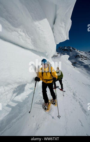 Kletterer unter Gesims während Schneeschuh Tour an Seekarschneid, Obertauern, Salzburger Land, Österreich Stockfoto