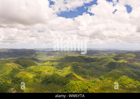 Hügel mit Regenwald, Blick auf die Luft. Tropische Landschaft mit Dschungel. Tropisches Klima, Natur der Philippinen. Hügelland und Himmel mit großen Wolken. Stockfoto