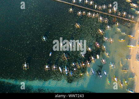 Viele Boote am frühen Morgen, Ansicht von oben. Stadt Allgemeine Luna an der Küste von Siargao mit einem Pier, ein Hafen und touristische Boote. Marina mit Booten. Stockfoto