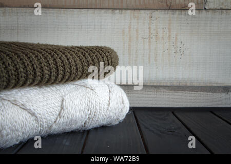 Nahaufnahme von zwei Gewirke aus natürlichen wolle Pullover, auf einem schwarzen Holztisch, selektiver Fokus Stockfoto