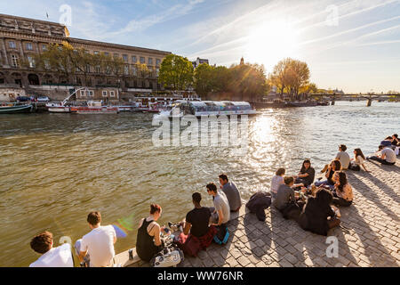 Frankreich, Paris, Seine, Ausflugsschiff, junge Menschen am Ufer entlang des Regionalrats de la CitÃ© Stockfoto