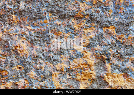 Gold Fragmente auf der grau-blauen Gips der alten Mauer. Stockfoto