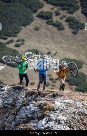 Radfahrer können ihre Fahrräder auf die Peilspitze, Gschnitztal, Stubaier Alpen, Tirol, Österreich, beim Klettern auf den Gipfel. Stockfoto