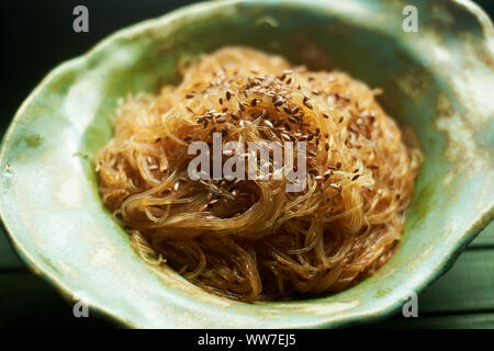 Cellophan mit Sesamsamen mit süßer und saurer Soße.in einer tiefen Keramikschale handgefertigt. Appetitliches Gericht. Stockfoto