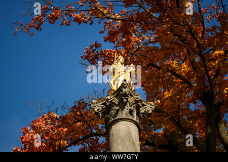 Eine goldene Statue der Jungfrau Maria unter blauem Himmel im Herbst, Low Angle View Stockfoto