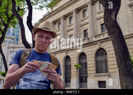 Junger Mann touristische zählt Geld auf der Straße Stockfoto