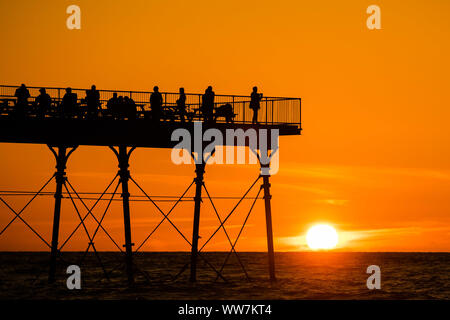 Aberystwyth Wales UK, Freitag 13 September 2019 Leute stehen an der viktorianischen Badeort von Aberystwyth Pier ab, als sie die letzten Strahlen der Sonnen zusehen, wie es über die Cardigan Bay, auf eine glorreiche Anfang Herbst abends, am Wochenende wird erwartet, warm mit Temperaturen in der Mitte 20 Celsius in Teilen der Südosten der UK Photo credit Keith Morris/Alamy Leben Nachrichten beigelegt werden Stockfoto