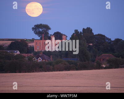 Eastchurch, Kent, Großbritannien. 13. September, 2019. UK Wetter: Die vollständige Harvest Moon gesehen steigende über historische Shurland Halle (wo Henry VIII seine Flitterwochen verbracht) in Eastchurch, Kent an diesem Abend. Credit: James Bell/Alamy leben Nachrichten Stockfoto