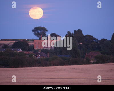 Eastchurch, Kent, Großbritannien. 13. September, 2019. UK Wetter: Die vollständige Harvest Moon gesehen steigende über historische Shurland Halle (wo Henry VIII seine Flitterwochen verbracht) in Eastchurch, Kent an diesem Abend. Credit: James Bell/Alamy leben Nachrichten Stockfoto