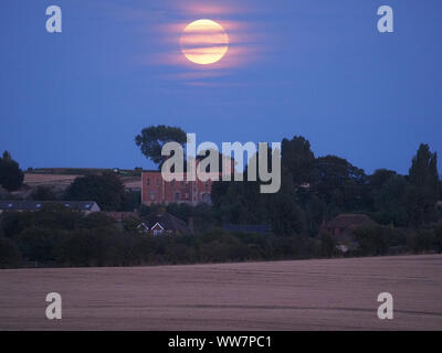 Eastchurch, Kent, Großbritannien. 13. September, 2019. UK Wetter: Die vollständige Harvest Moon gesehen steigende über historische Shurland Halle (wo Henry VIII seine Flitterwochen verbracht) in Eastchurch, Kent an diesem Abend. Credit: James Bell/Alamy leben Nachrichten Stockfoto