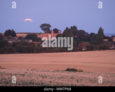 Eastchurch, Kent, Großbritannien. 13. September, 2019. UK Wetter: Die vollständige Harvest Moon gesehen steigende über historische Shurland Halle (wo Henry VIII seine Flitterwochen verbracht) in Eastchurch, Kent an diesem Abend. Credit: James Bell/Alamy leben Nachrichten Stockfoto